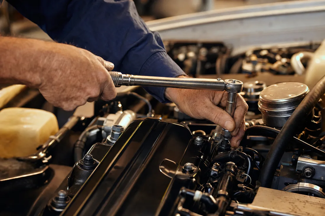 A technician torquing a fastener on an engine in the shop